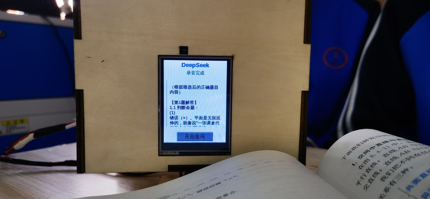 图 4-11 整机联调完成:木质外壳中的行空板屏幕正在显示 AI 讲解,下方是摊开的数学课本